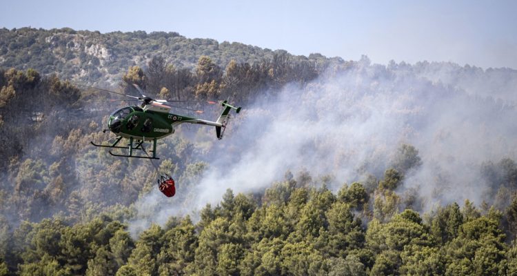 Un helicóptero combatiendo en un incendio forestal.
