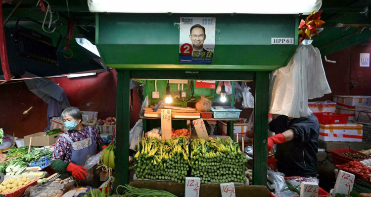 El panfleto de un candidato sobre un puesto de frutas en Hong Kong.