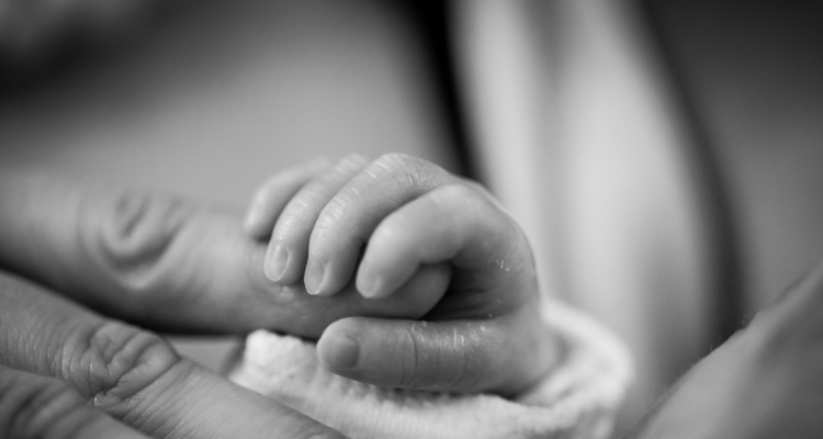 Imagen conceptual de la mano de un bebé recién nacido