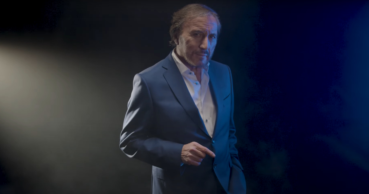 El periodista Carlos Pinto caminando entre el humo clásico de sus programas.