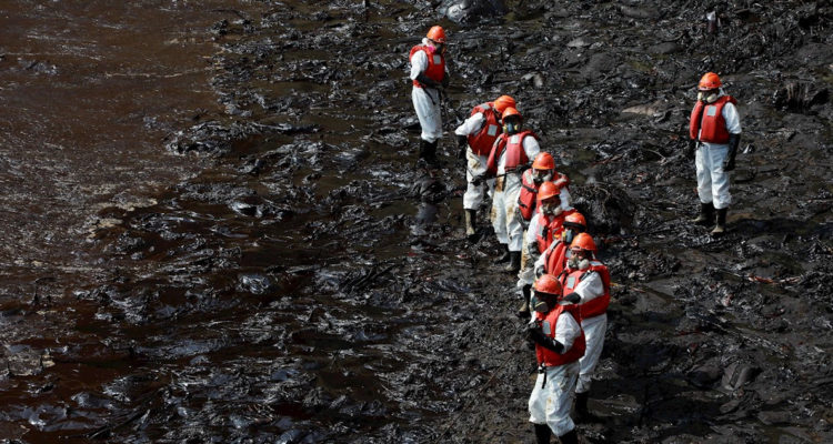 Funcionarios trabajando en contener el derrame de petróleo.