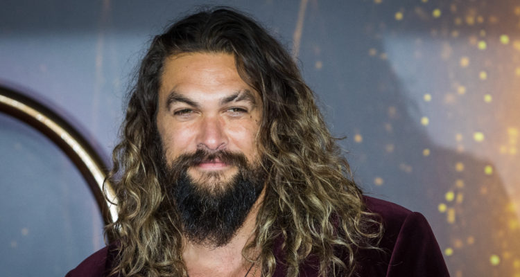 El actor Jason Momoa sonriendo a la cámara durante la premiere de Dune.