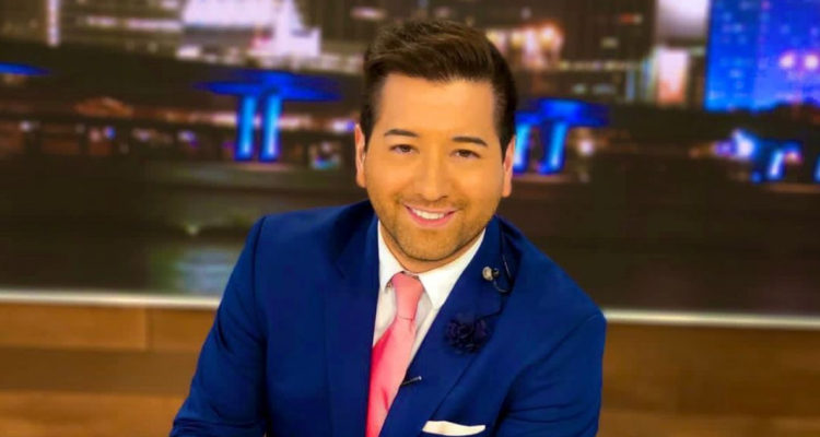 Javiera Olivares sonriendo a la cámara en medio de un set de un noticiario.