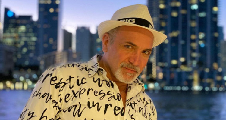 Luis Jara utilizando un sombrero y sonriendo a la cámara.