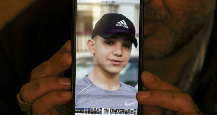 Fotografía del menor en un celular sujeto por su padre.