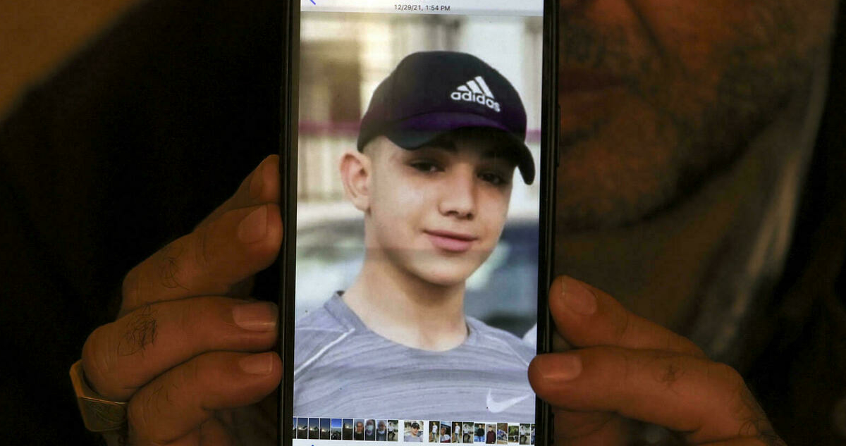 Fotografía del menor en un celular sujeto por su padre.