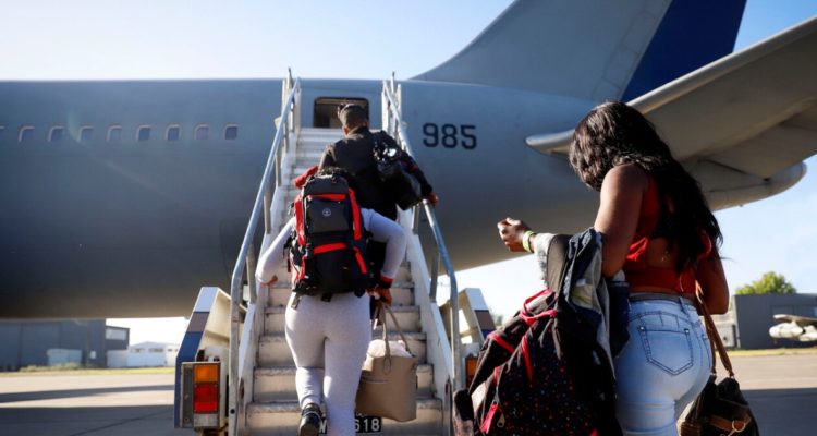Migrantes viajan en avión