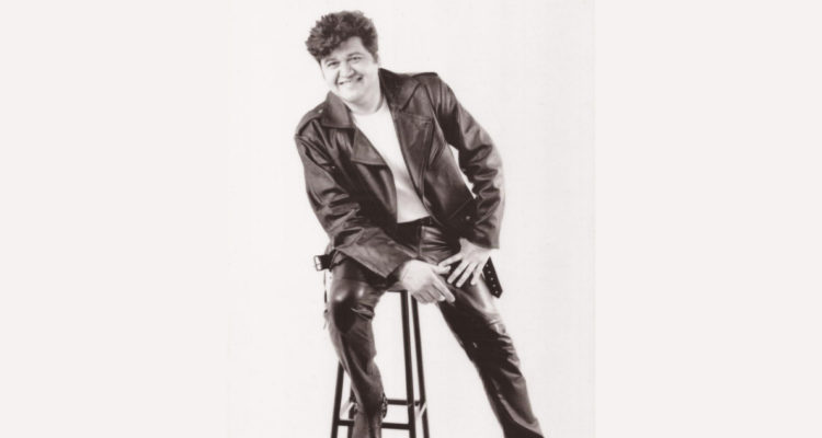 Fotografía de Francisco Serra de a mediados de los 90. Aparece sentado en una silla alta sonriendo a la cámara.