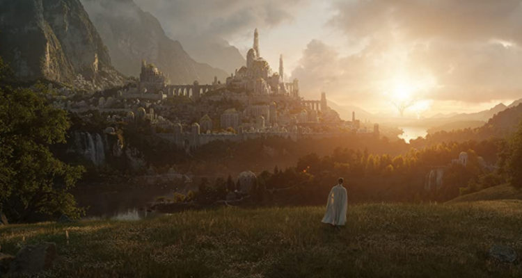 Una mujer vestida de blanco está de pie en un prado verde. Al fondo, se logra ver un castillo inmenso. Es la primera imagen hasta el momento de la serie de El Señor de los Anillos.