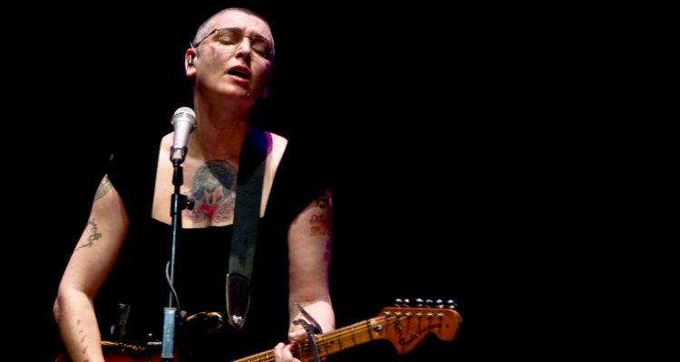 La cantante irlandesa Sinead O’Connor durante un concierto. Aparece cantando y tocando la guitarra.