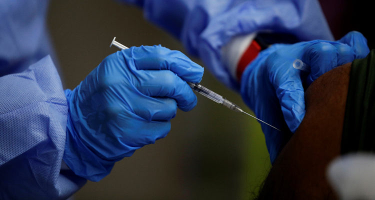 Un funcionario de salud vacuna a una persona contra el COVID-19.