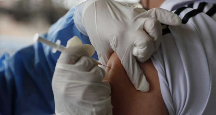 Un funcionario de la salud vacuna a otra persona contra el coronavirus. Una de las vacunas que se implementan es la de Pfizer.