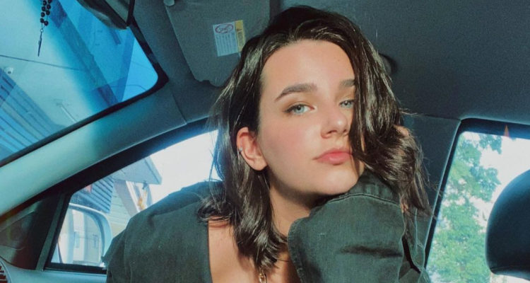 La modelo Valentina Boscardin posando ante la cámara. usa un polerón grande y sostiene su rostro apoyada con una mano.