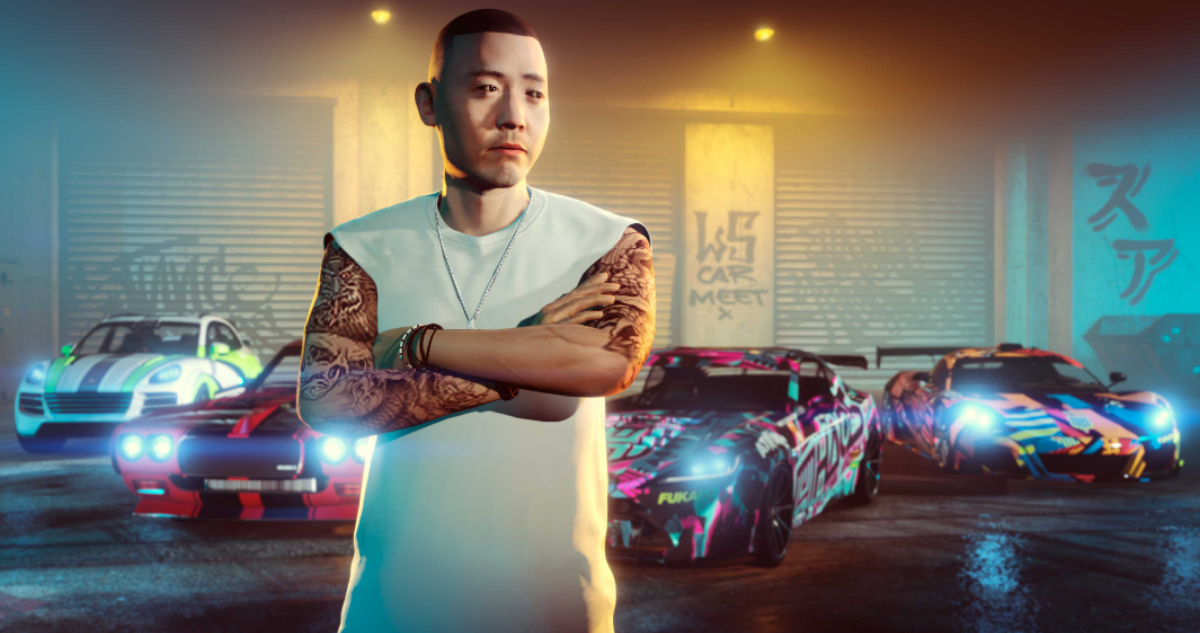 Una imagen de Grand Theft Auto Online. En ella se ve a un hombre asiático cruzado de brazos que tiene en su espalda tres autos deportivos.