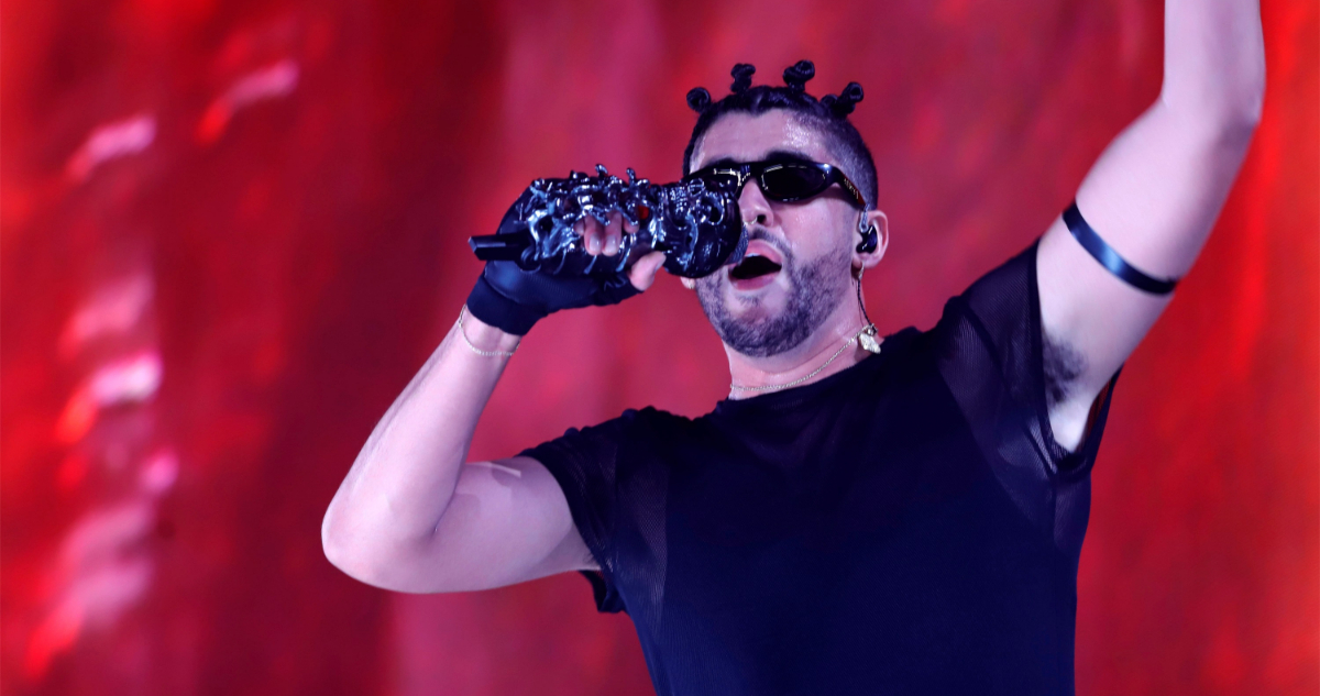 Bad bunny usa lentes de sol mientras canta en uno de sus conciertos.
