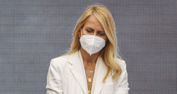 La modelo y diseñadora de modas Cecilia Bolocco vestida de blanco y usando una mascarilla.