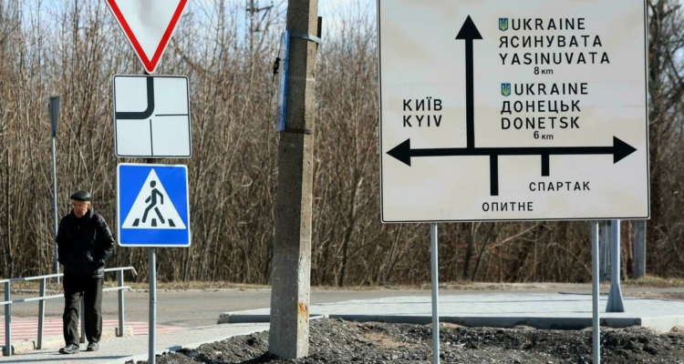 Un hombre pasa junto a una señal de tráfico en la ciudad de Avdiivka, región de Donetsk, ubicada en la línea del frente con los separatistas respaldados por Rusia.