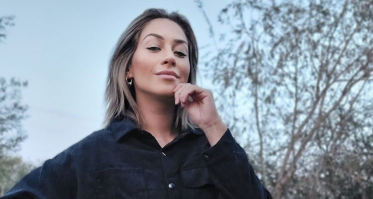 La modelo Ingrid Aceitón aparece con una mano en la barbilla con una leve sonrisa.