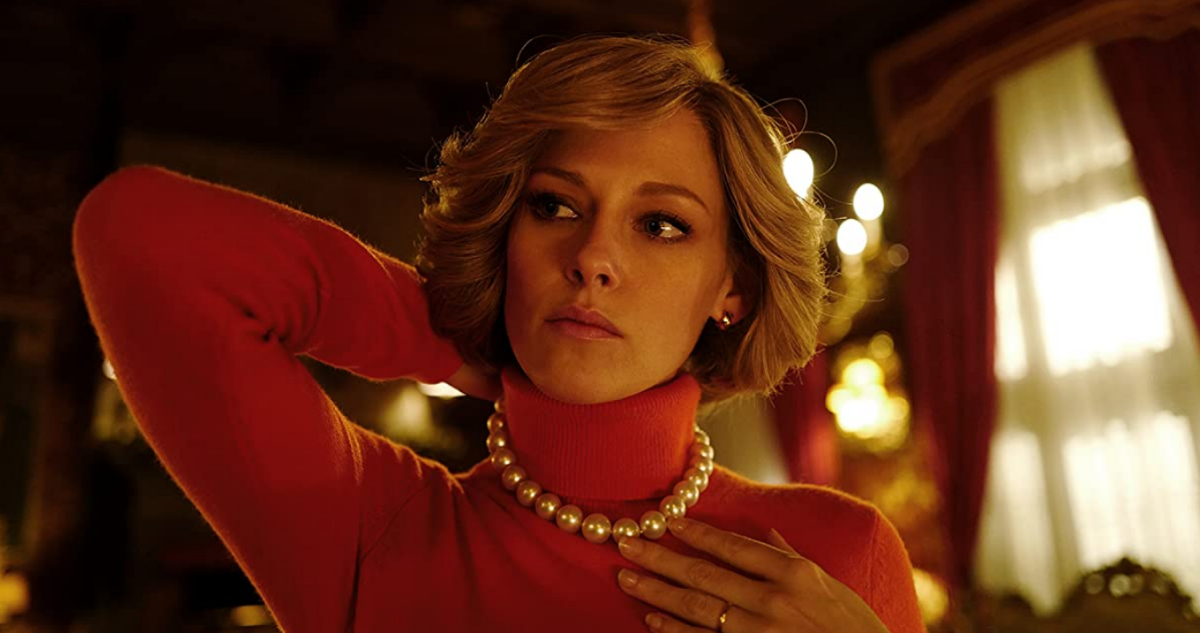 La actriz Kristen Stewart bajo su papel de Diana de Gales en la película Spencer. Utiliza un sweater con cuello de tortuga mientras se acomoda un collar de perlas.