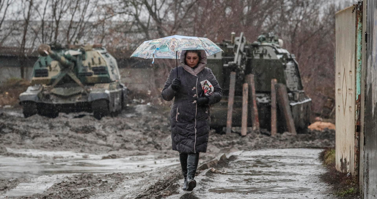 mujer camina entre vehículos rusos