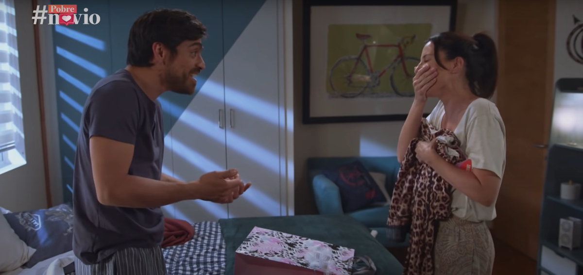 En la imagen Santiago comenta lo horrible que está la ropa deportiva que eligió para Alicia, mientras ella se tapa la boca mientras ríe, a la vez que sostiene las prendas con la otra mano.