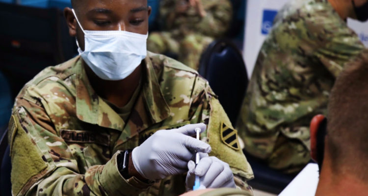 Militar vacunando a compañero