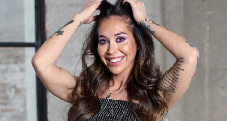 Valentina Roth con las manos en su cabeza mientras sonríe a la cámara.