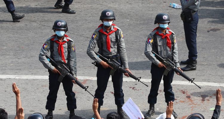 Policías birmanos frente a manifestantes.