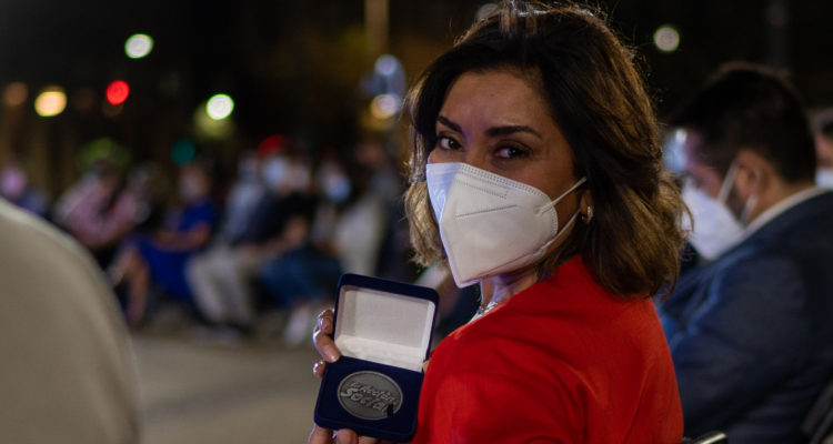 La abogada Carmen Gloria Arroyo muestra la medalla recibida gracias a su labor en Carmen Gloria a tu Servicio.