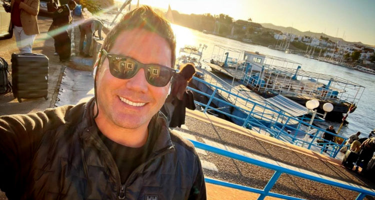 Pancho Saavedra sonriendo en un muelle contra la luz del sol.