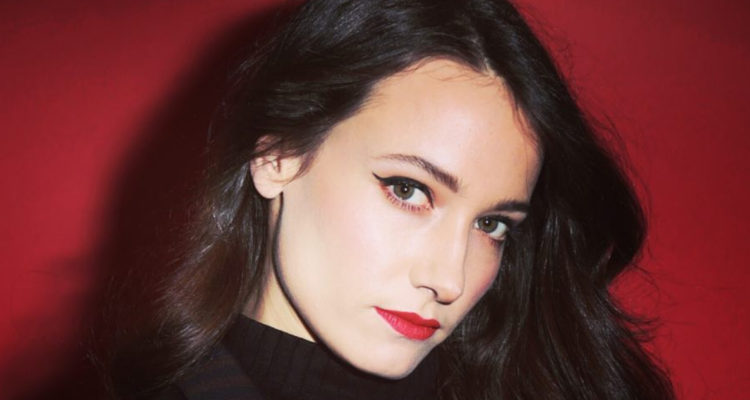 Geraldine Neary mira a la cámara de costado seria.