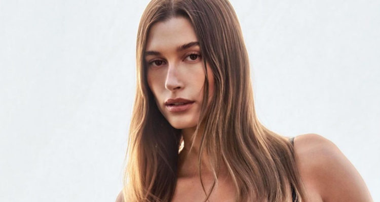 Hailey Bieber mirando seria a la cámara mientras posa.