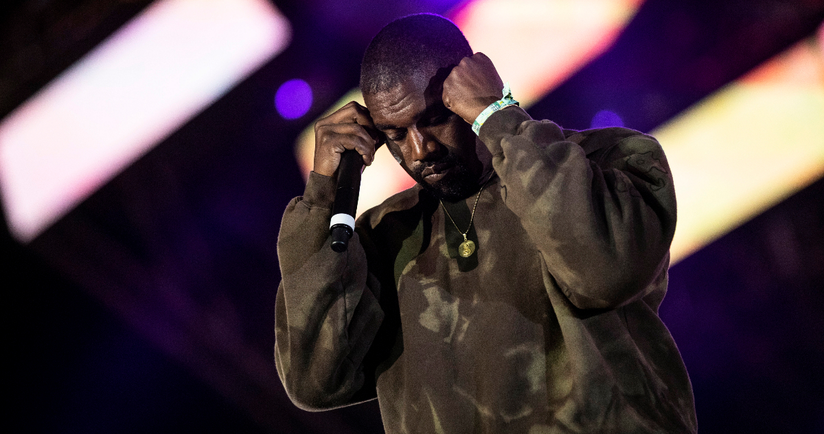Kanye West sujeta su cabeza en medio de un concierto.