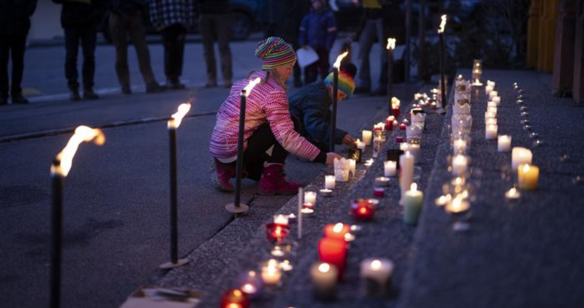 Dos niñoss prendiendo velas en pos de la paz en Ucrania.