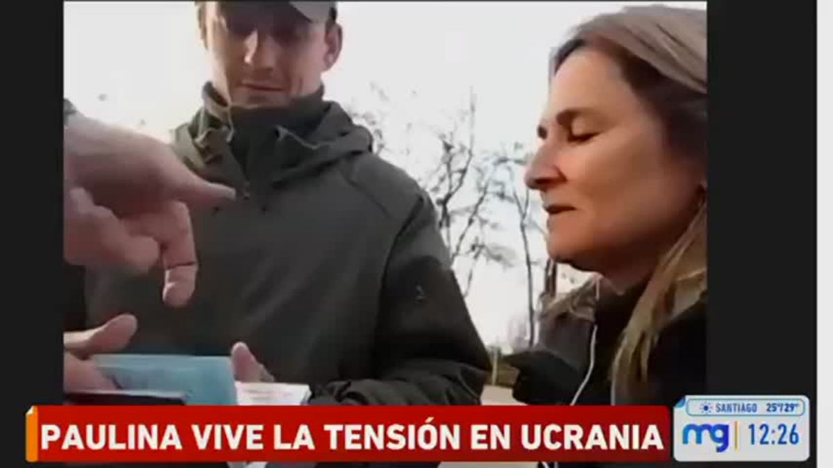 La periodista Paulina de Allende-Salazar mostrando sus documentos a militares ucranianos en la frontera.