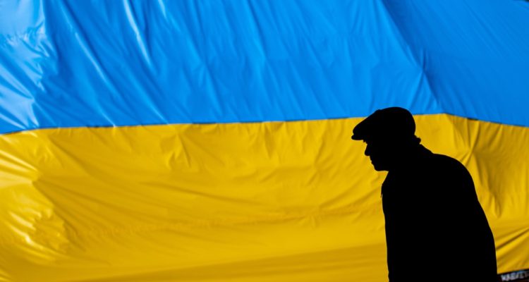 Un refugiado junto a una bandera ucraniana