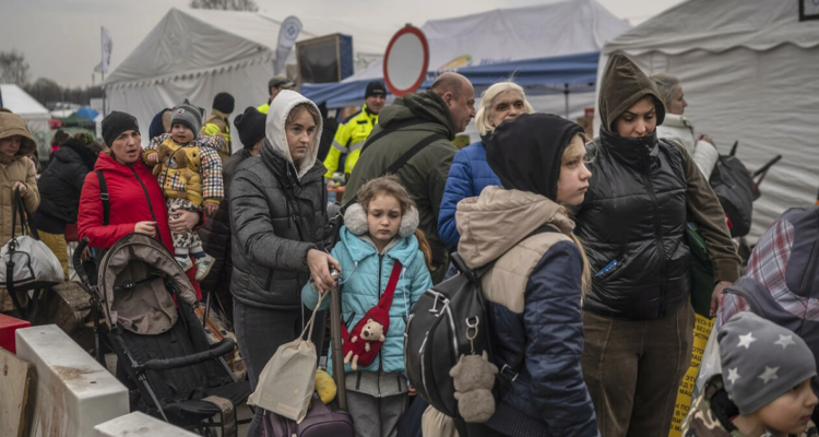 Decenas de ucranianos aguardan a tomar un medio de transporte en un puesto fronterizo polaco tras salir de su país, el 29 de marzo de 2022 en Medyka, al sureste de Polonia.