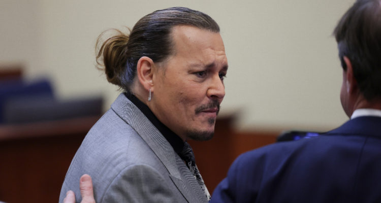Johnny Depp hablando con su abogado en medio del juicio contra Amber Heard.