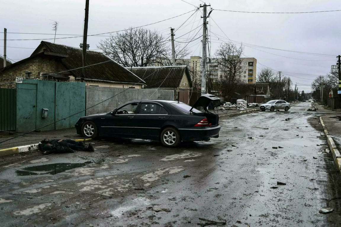Un cadáver yace junto a un coche en una calle de Bucha, una ciudad al noroeste de Kiev.
