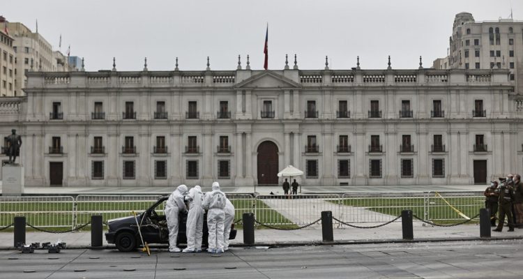 Peritos trabajando en el vehículo incendiado frente a La Moneda.