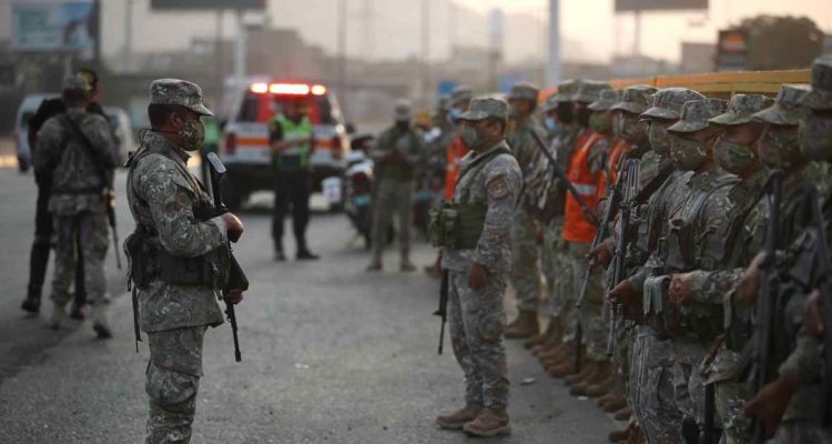 Militares y policías se preparan para realizar controles en un paradero de transporte público hoy martes en las calles de Lima.