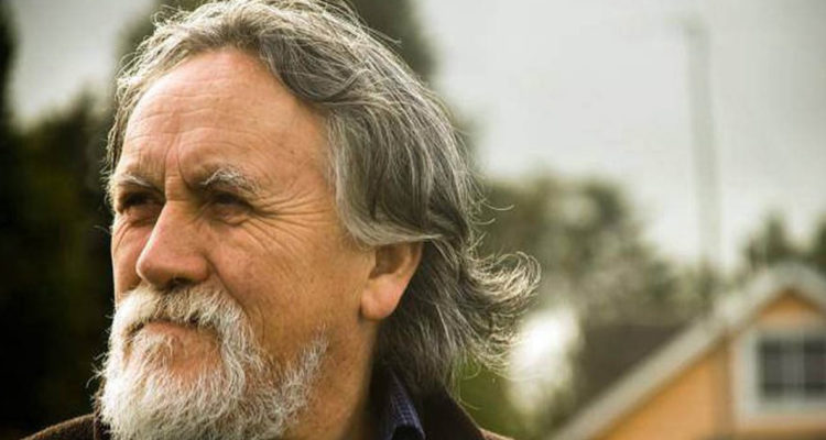 Renato Cárdenas aparece visto de cerca, aparece serio mirando hacia un costado.