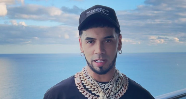 El cantante Anuel AA posando en un crucero, donde se ve el océano de fondo. El músico debió cancelar dos de sus conciertos en Chile.