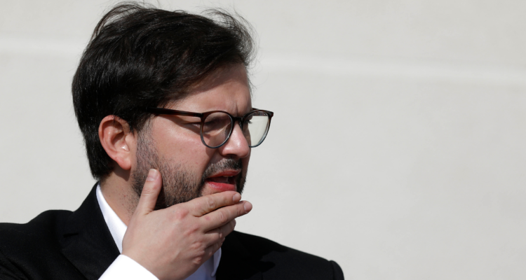 Fotografía del presidente, Gabriel Boric, llevándose la mano al mentón.