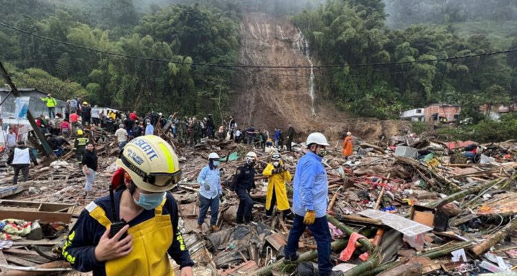 Autoridades y miembros de cuerpos de rescate trabajan en una zona afectada por un deslizamiento de tierra causado por las fuertes lluvias.