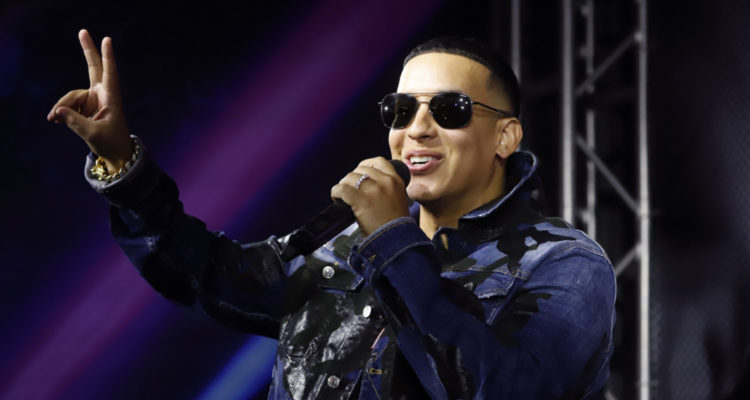 Daddy Yankee saludando a su público en medio de un concierto.
