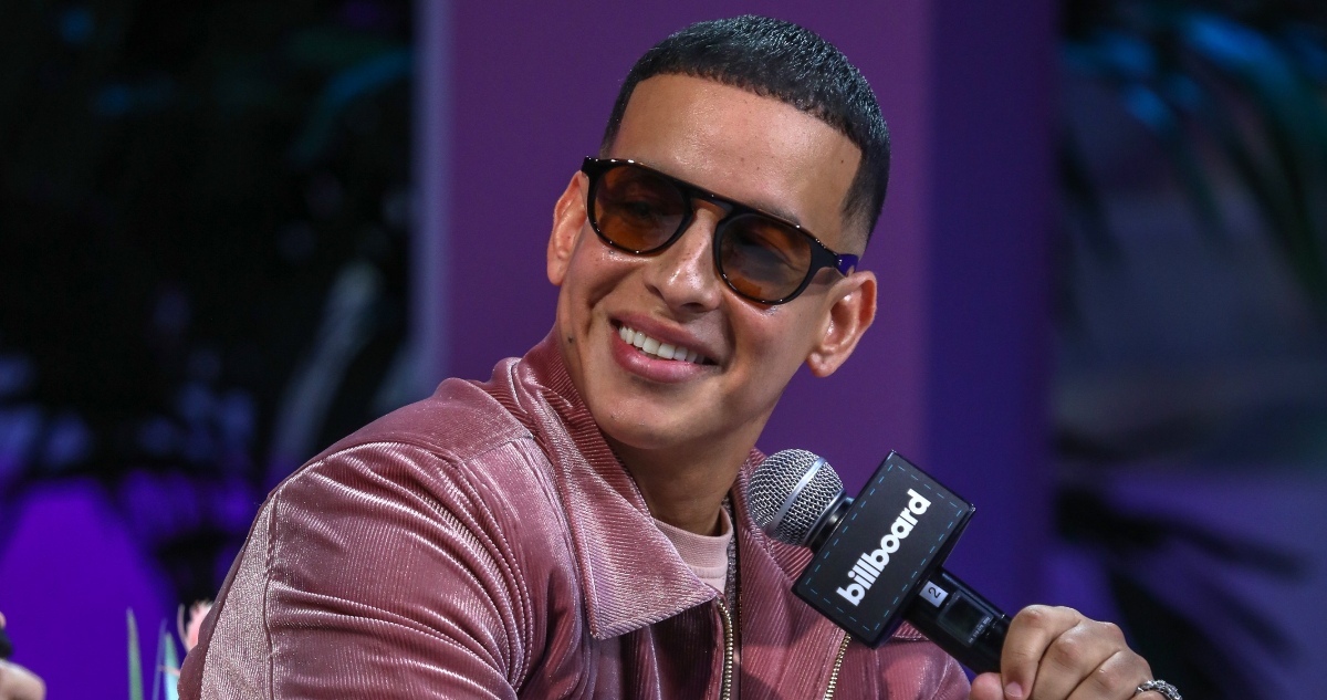 Daddy Yankee sonriendo y mirando hacia un lado.
