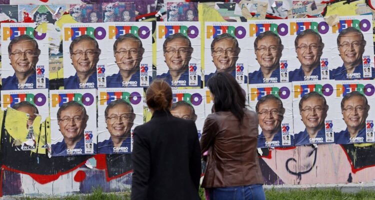 Personas caminan hoy cerca a volantes publicitarios del candidato presidencial colombiano Gustavo Petro.