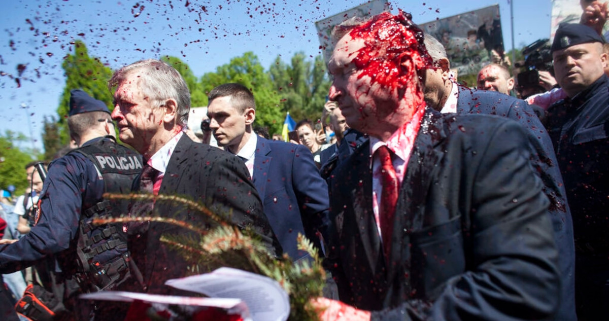 El embajador ruso, manchado con la pintura roja mientras manifestantes proucranianos protestan a sus espaldas.