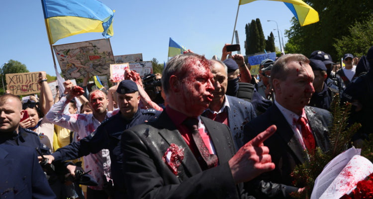El embajador ruso, manchado con la pintura roja mientras manifestantes proucranianos protestan a sus espaldas.
